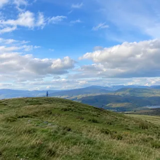 A person as a tiny speck on a distant hilltop