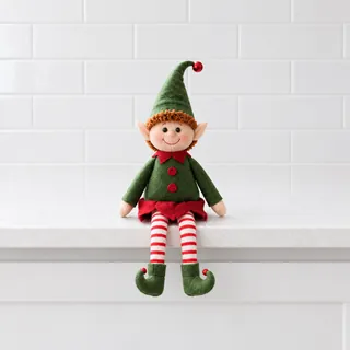 The elf doll on a white counter with empty space around it