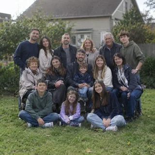 About fifteen relatives squeezed into three rows on a lawn