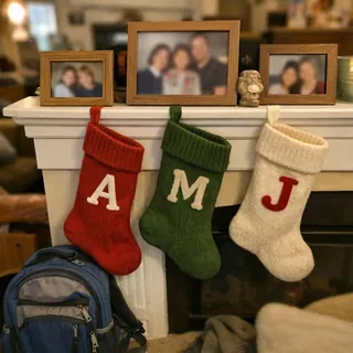 Mantel with framed family photos, stockings with initials and a school backpack