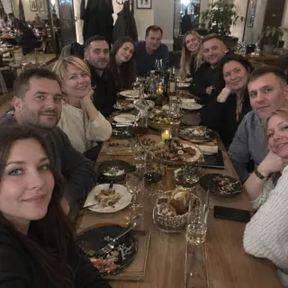 A large group of friends crowded around a long restaurant table