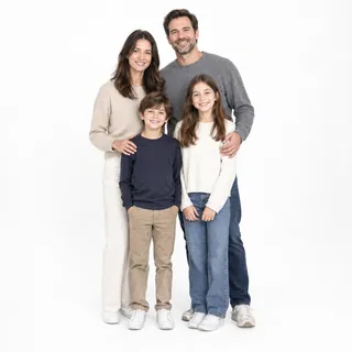 Family of four standing close together on white, all facing the camera