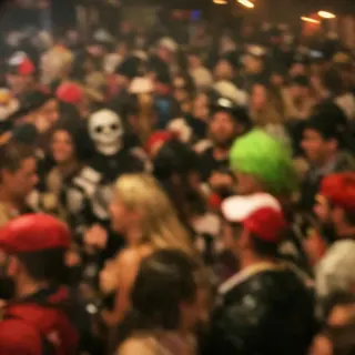 A dark, crowded costume party photo with many small faces