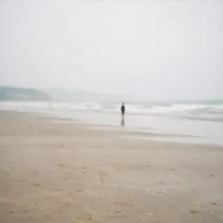 海滩上一个远处的人影，脸小得看不清