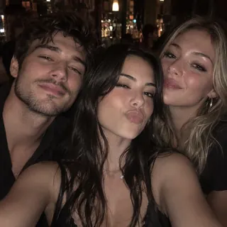 Three friends crowded into one selfie in a dim bar
