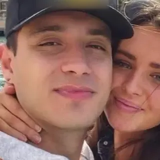 A couple's daylight selfie, cheek to cheek, both faces clear