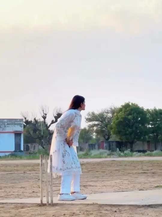 The batter seen from the side on a village ground, framed from head to feet