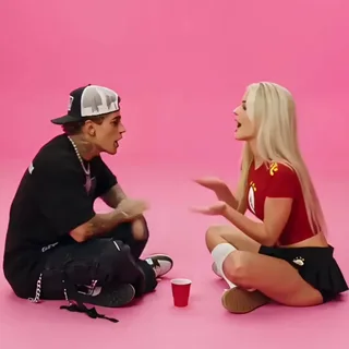 Two people sitting together on a pink floor