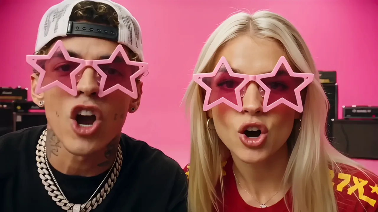 Close-up of two performers in pink star-shaped sunglasses singing toward the camera