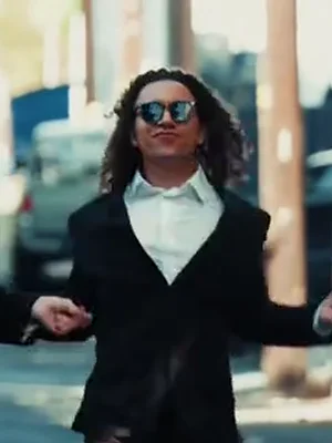 The right dancer in the example, with long curly hair, a black suit and a white shirt