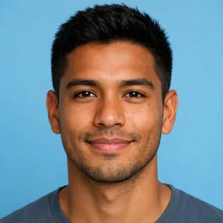 Close portrait of a smiling man with short black hair looking straight at the camera