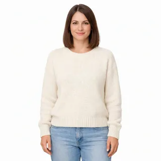 Waist-up photo of a woman in a cream sweater facing the camera on a plain white background