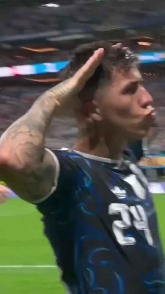Opening move: under stadium lights the scorer stands side-on with one hand cupped behind the ear