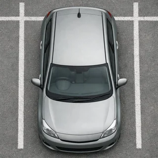 A silver hatchback seen from straight above in a parking space