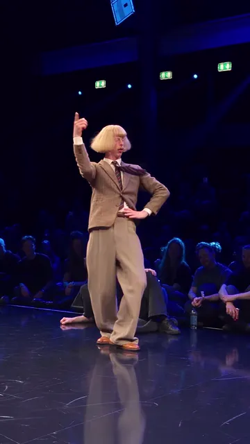 Dancer pointing one finger up with his other hand on his hip