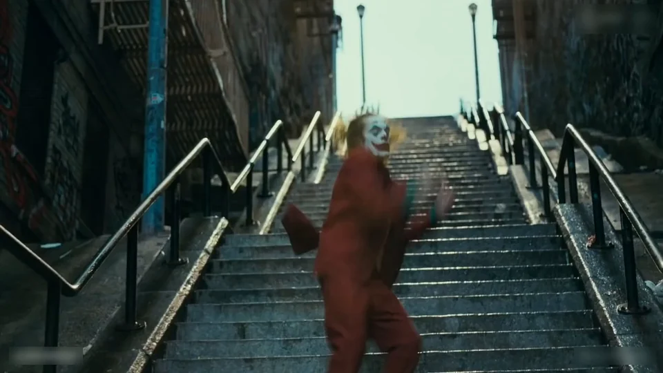 The dancer with both arms spread wide on the steps, hips swung to one side