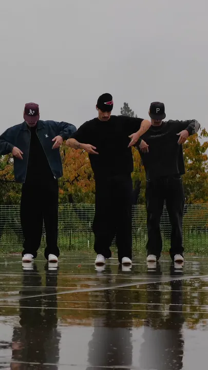 The three dancers with their forearms rolled in front of the chest.