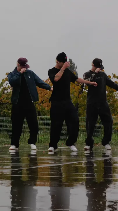The three dancers lift one hand up past the face.