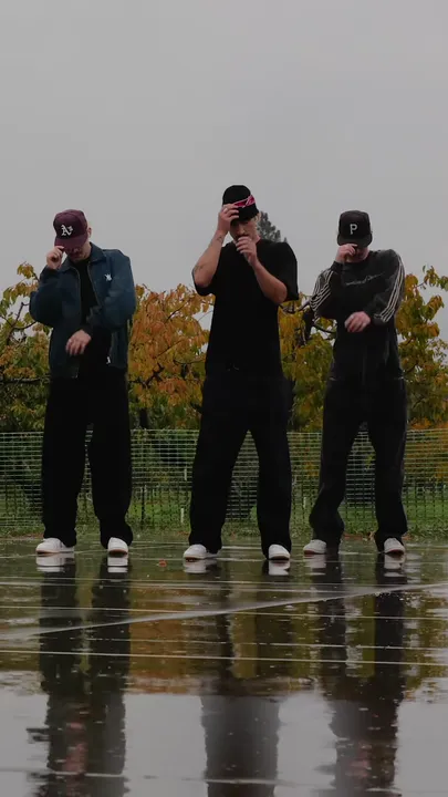 Heads down, each dancer holds the brim of his hat.