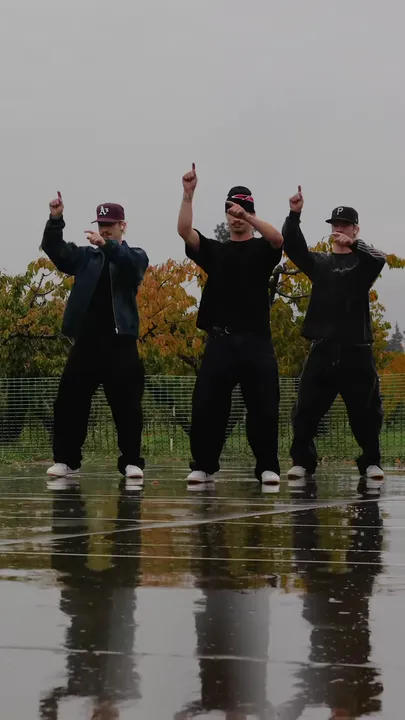 Arms raised, each dancer points one finger up.