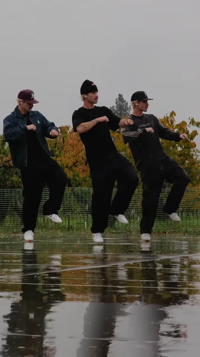 Each dancer lifts one knee into a side kick.