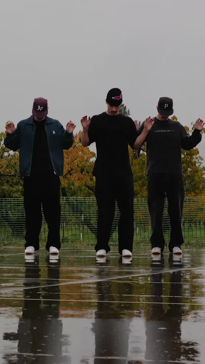 The three dancers with their hands raised loosely beside the shoulders.