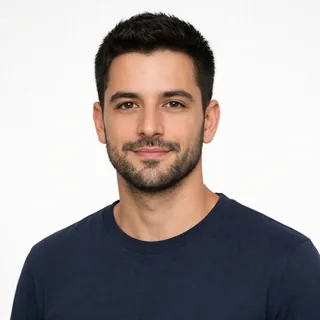 Front-facing portrait of a bearded man in a navy t-shirt on a white background