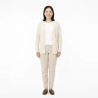 A woman in a cream cardigan facing the camera on a white background, her face fully visible