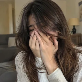 双手捂脸大笑的女生，背景是虚化的客厅