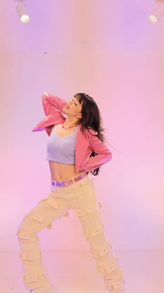 A closer view of the dancer leaning back with one hand behind her head and the other on her hip