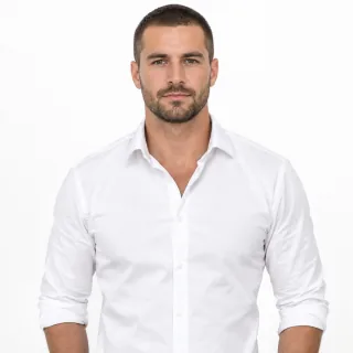 Waist-up photo of a man in a crisp white shirt standing straight on a white background