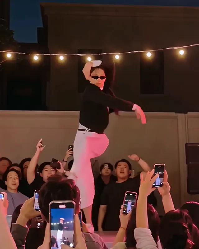 The dancer kicking one knee up high with one arm bent over the head