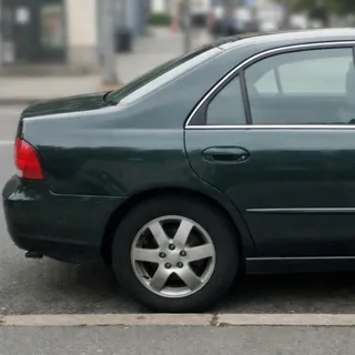 Dark green sedan cropped so its front end is outside the frame