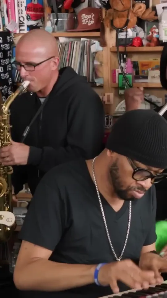 Band shot again: keyboard player leaning into the keys, sax player playing behind