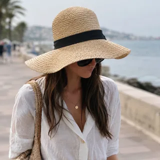 Woman whose face is hidden by a wide sun hat and dark sunglasses