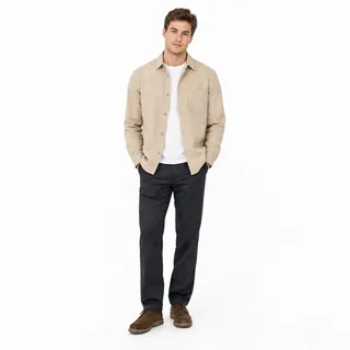 Full-length photo of a man in a beige overshirt and dark trousers on a white background