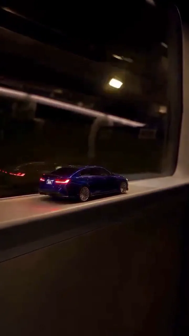 The train window in darkness with the small car's tail lights glowing