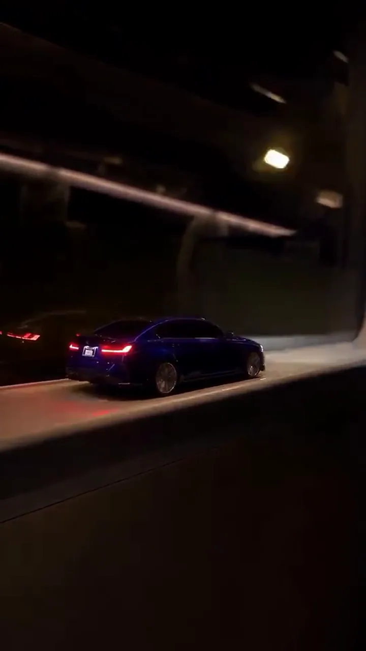 A dark train window during the tunnel with the small car's tail lights on