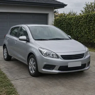 A silver hatchback parked in a driveway with no one in the photo